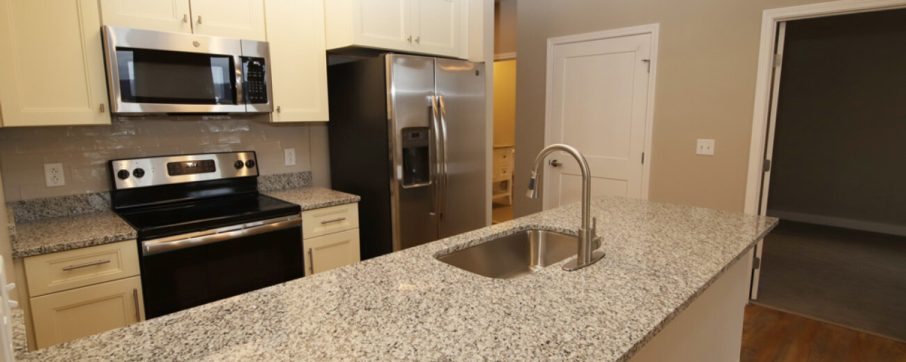 Kitchen within a one-bedroom unit in 100 West Water Apartments.